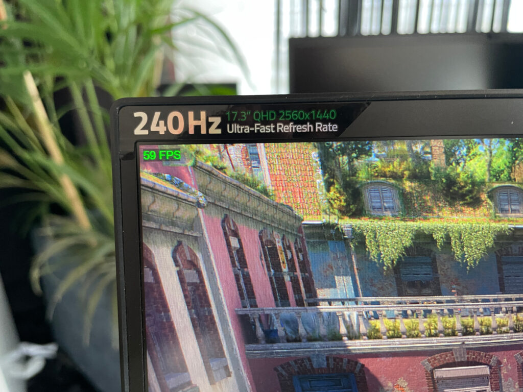 Detail Bildschirmecke vom Razer Blade 17, die bunte Hausfront zeigt