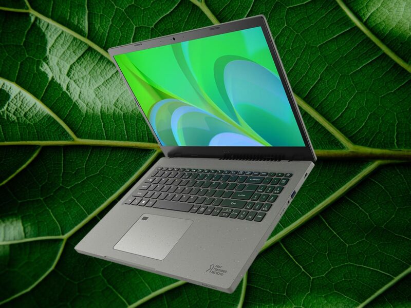 Acer Aspire Vero aufgeklappt schräg von vorne mit grünem Bildschirm auf grünem Blattartigen Hintergrund
