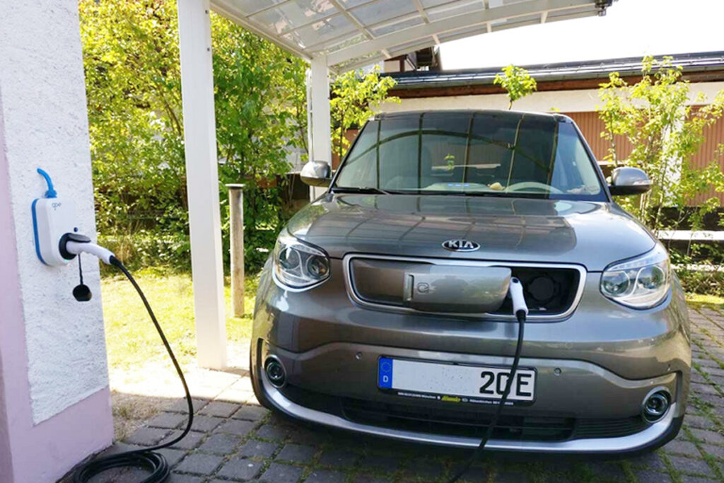 E-Auto wird über eine Wallbox in einem Carport mit Strom geladen.