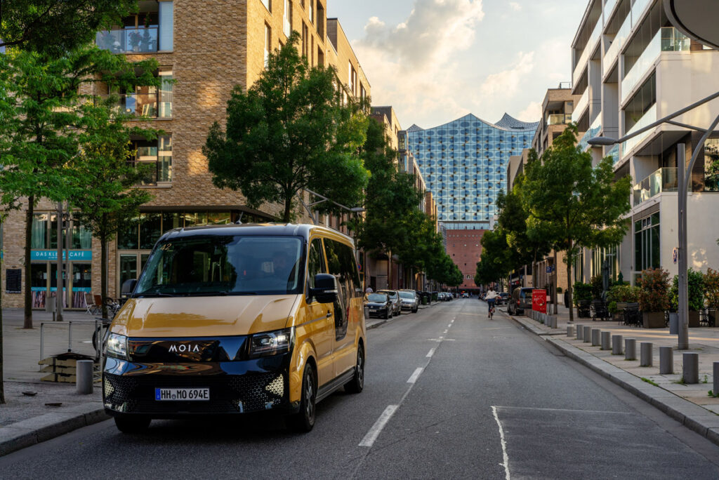 Moia-Sammeltaxi auf Straße in Hamburg vor Elbphilharmonie.