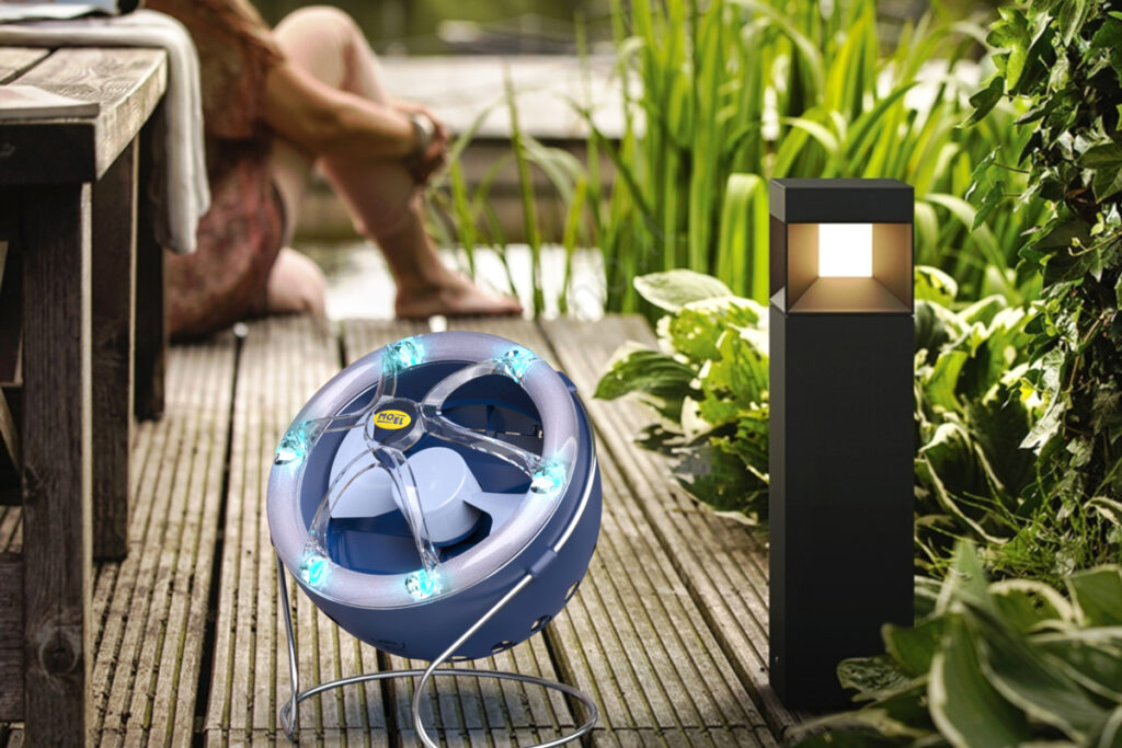 Ventilator als Insektevernichter auf einem Holzsteg vor einem Teich. 