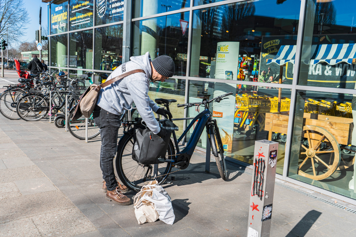 Mann packt Tasche am Trekking-E-Bike