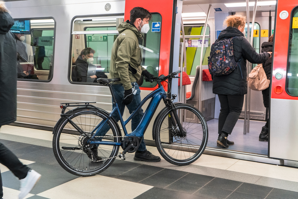 Mann steigt mit Trekking-E-Bike in die U-Bahn