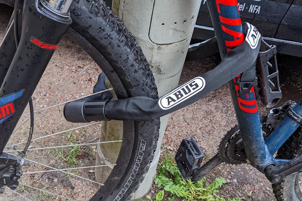 Mit schwarzem Fahrradschloss an Laternenpfahl angekettetes Fahrrad