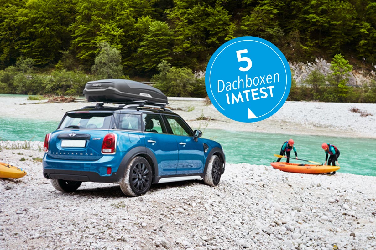 Ein Mini mit Dachbox am Flussufer.