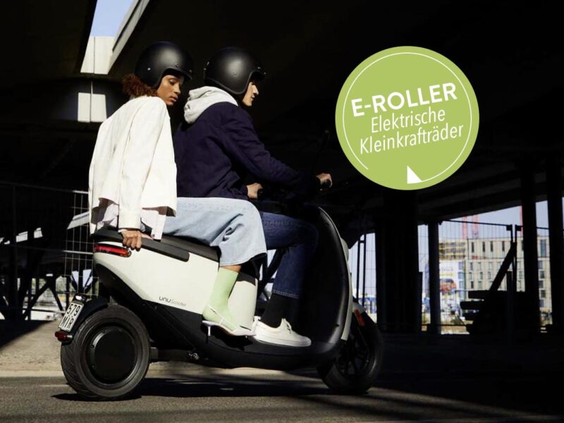 E-Roller mit zwei Personen im Stadtverkehr