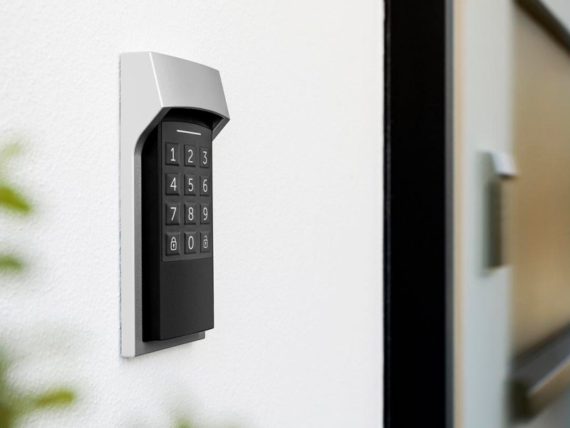 Weiß schwarzes längliches Tastenfeld von Homematic IP an GlasWand