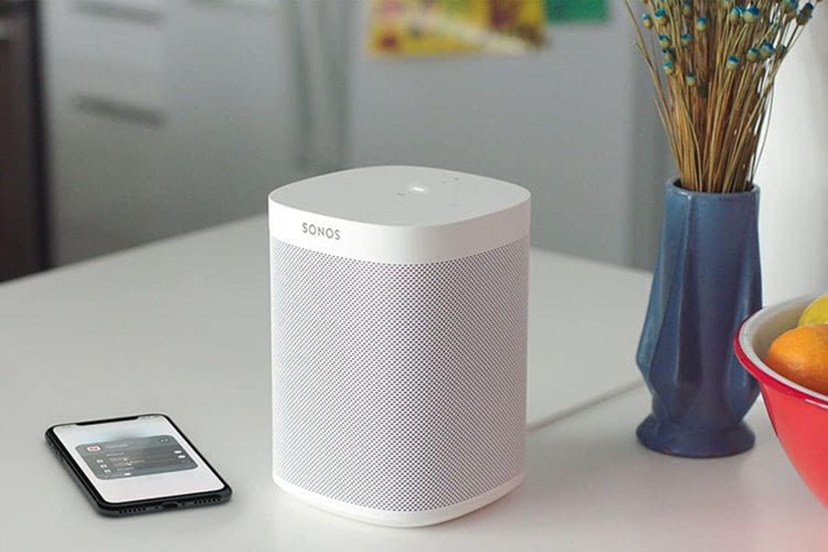 Ein Bluetooth-Lautsprecher von Sonos steht neben einem Smartphone auf einem Küchentresen.