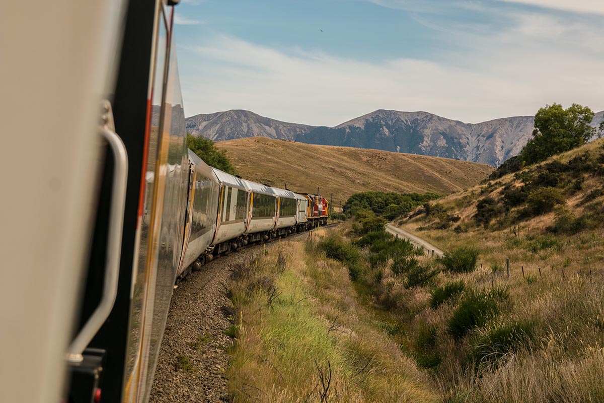 Ein Zug fährt durch eine bergige Landschaft.