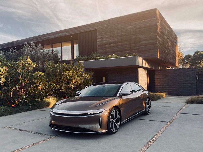 Der Elektrosportwagen Lucid Air steht vor einer Garage.