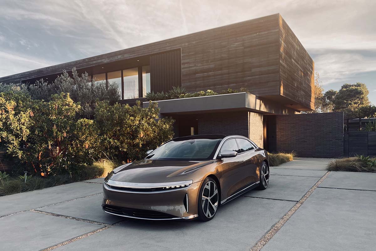 Der Elektrosportwagen Lucid Air steht vor einer Garage.