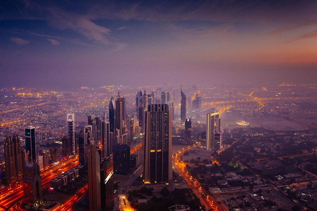Eine Großstadt wird bei Nacht aus der Vogelperspektive per Drohne fotografiert.