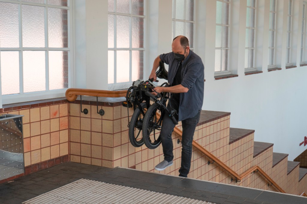 Falt-E-Bike wird die Treppe hochgetragen