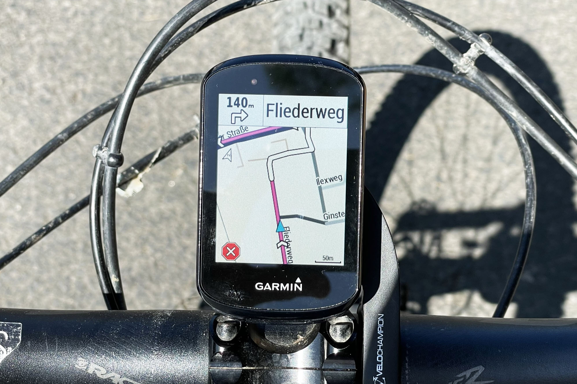 Schwarzes eckiges Fahrrad-Navi zeigt Route an Lenker von oben