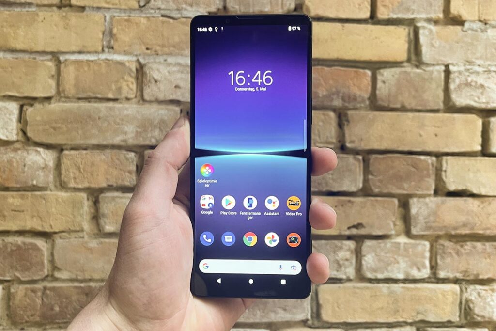 Eine Hand hält das Sony Xperia 1 IV vor einer Backsteinwand.