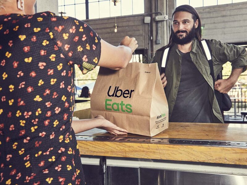 Ein Mann nimmt eine Essensbestellung von Uber Eats entgegen.