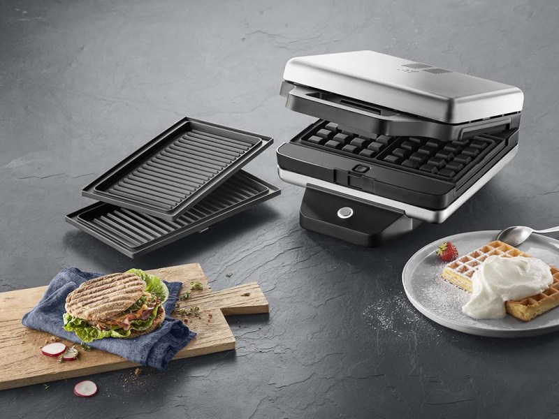 Der Lono Snack Master Pro von WMF mit einem Panini und einer Waffel.