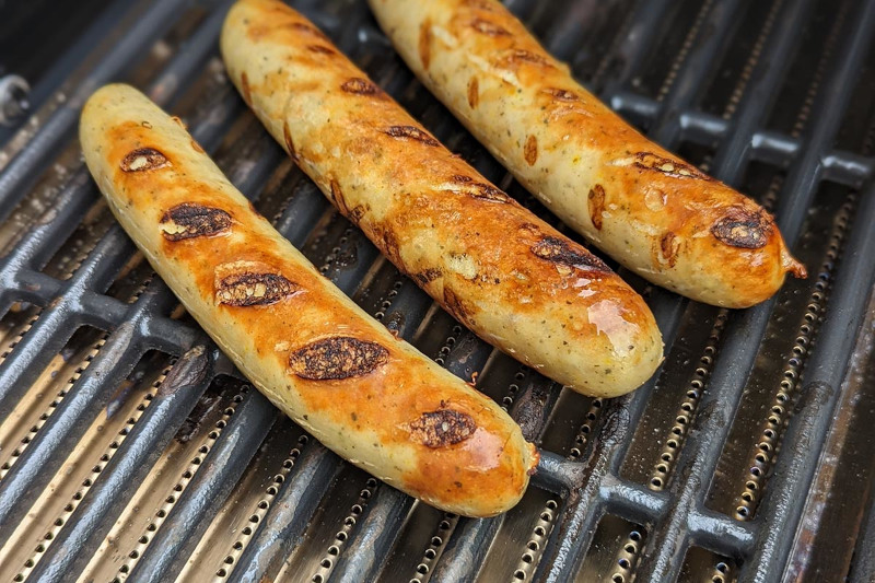 drei Gegrillte Bratwürste auf dunklem Rost vom günstigen Gasgrill Char-Broil