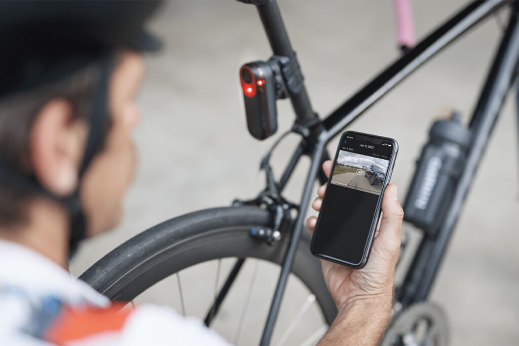 Fahrradfahrer mit Smartphone neben seinem Rad