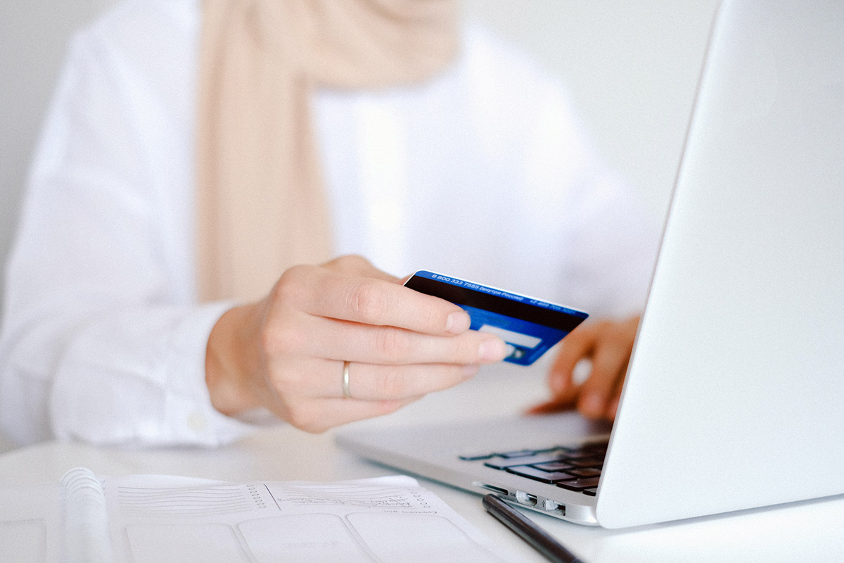 Eine Frau möchte mit einer Kreditkarte online bezahlen.