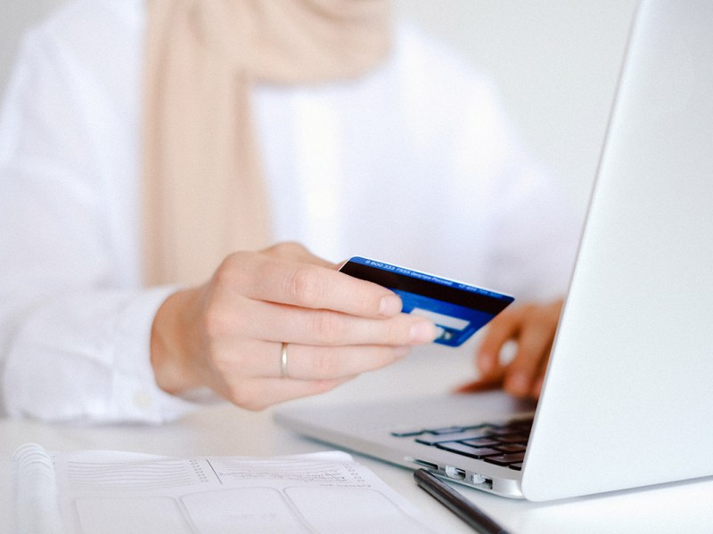 Eine Frau möchte mit einer Kreditkarte online bezahlen.