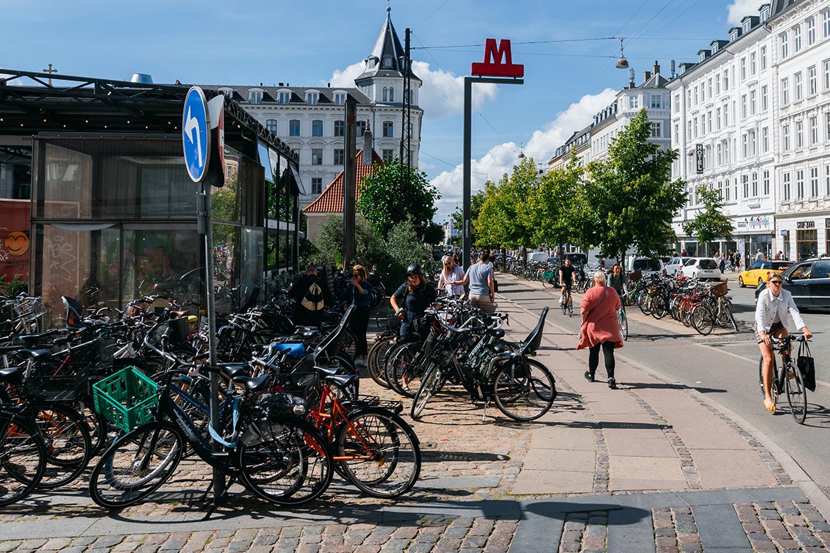 Viele Fahrräder an einer befahrenen Straße