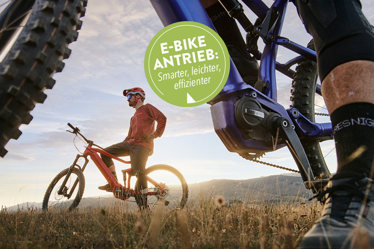 Zwei E-Mountainbike-Fahrer stehen mit Ihrenn Rädern auf einem Feld im Sonnenuntergang