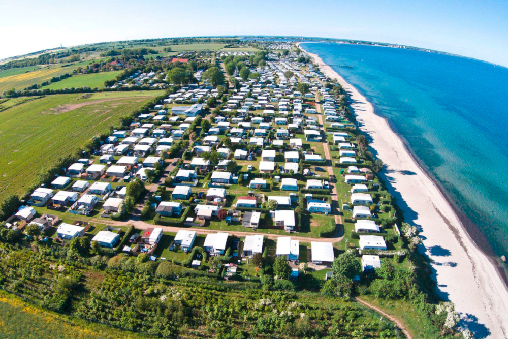 Campingplatz mit WOhnmobilen gefüllt von oben an der Küste