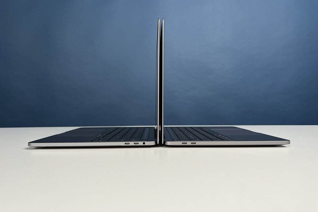 Zwei MacBook Pro mit identischem Gehäuse aufgeklappt Rücken an Rücken