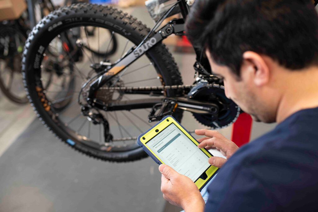 Mann liest digitale Daten von E-Bike aus