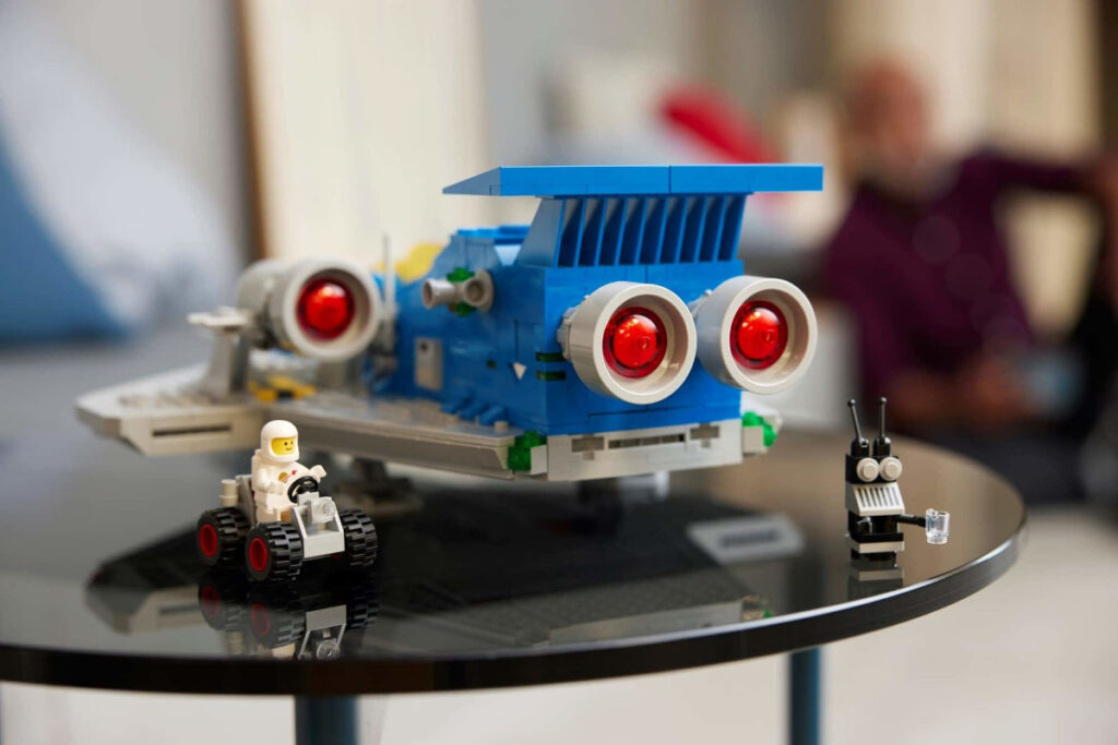 Lego grau blaues Raumschiff von hinten auf schwarzem Tisch mit Mini-figuren