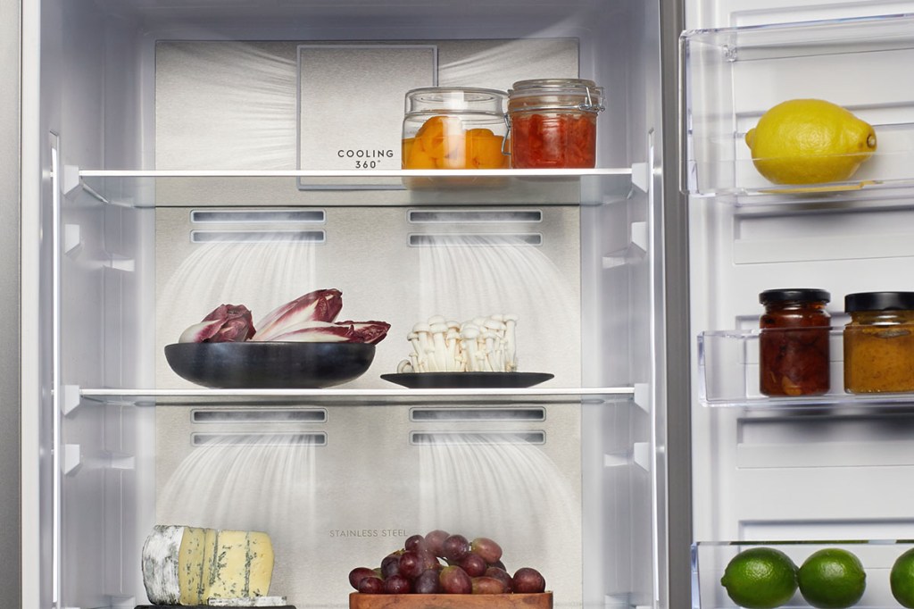 Ein Kühlschrank ist von innen zu sehen. Einigen Lebensmittel stehen darin. Aus den Schlitzen der Rückwand sind schematische Luftströmungen gezeigt.