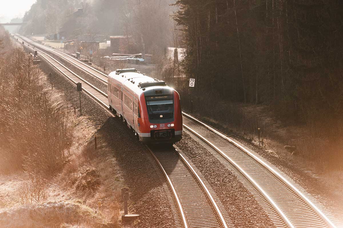 Eine Bahn fährt auf einer Schiene in einer Winterlandschaft.