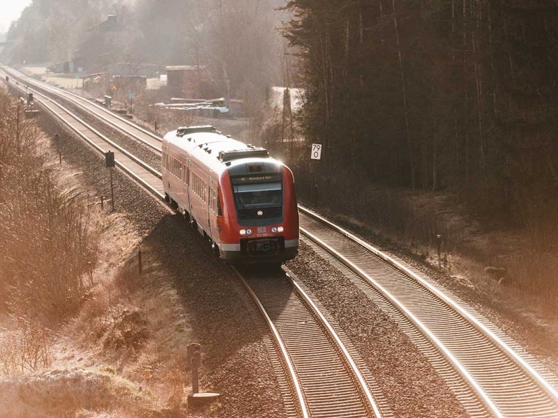 Eine Bahn fährt auf einer Schiene in einer Winterlandschaft.
