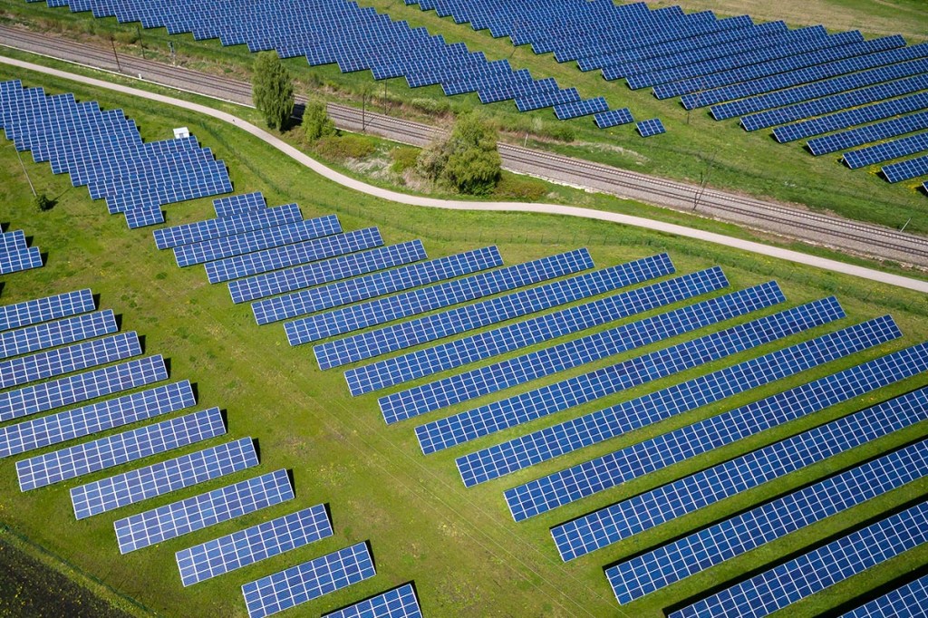 Ein Solarpark zwischen Schienen auf einem Feld