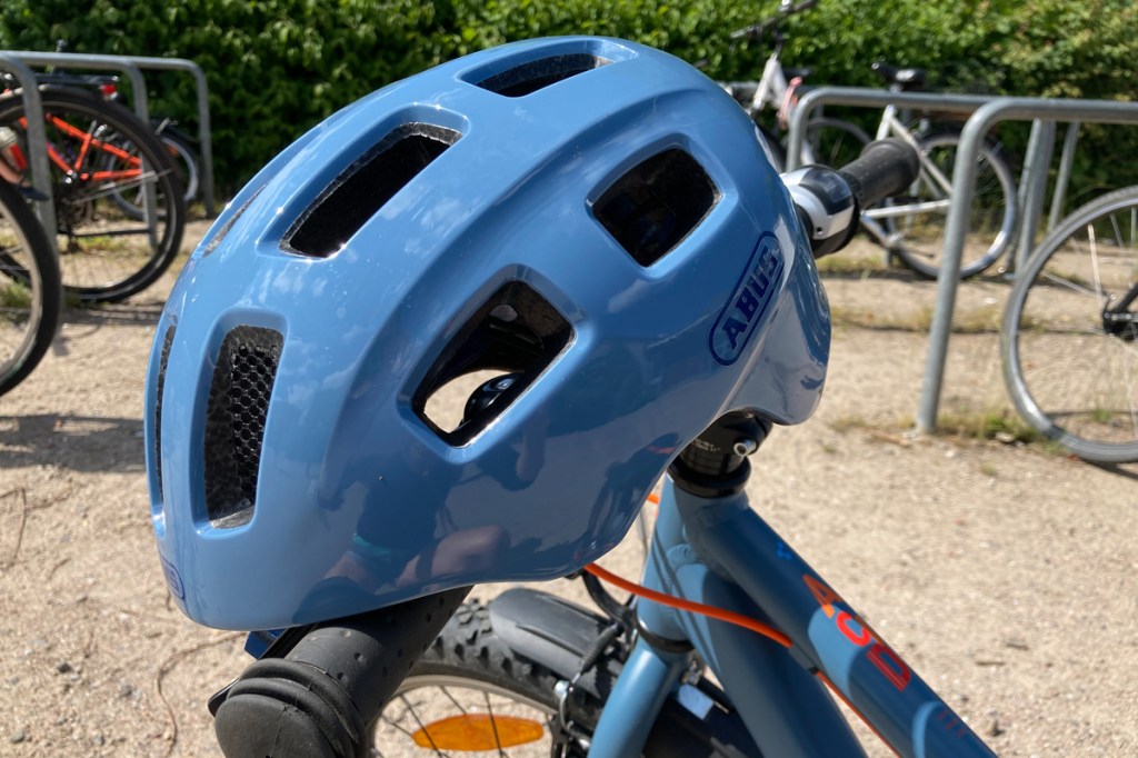 Abus Youn_I 2.0 children's bicycle helmet, seen from the side, helmet attached to a bicycle handlebar