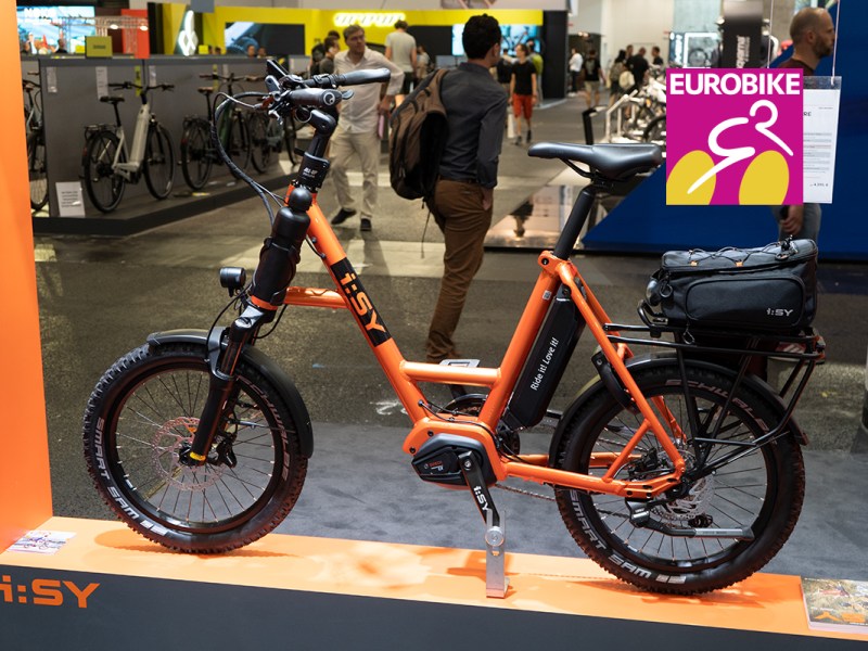 Das i:SY S10 Adventure , eines der ersten kompakten E-Mountainbikes mit Tiefeinsteiger-Rahmen steht auf einem Messesatnd der Eurobike 2022