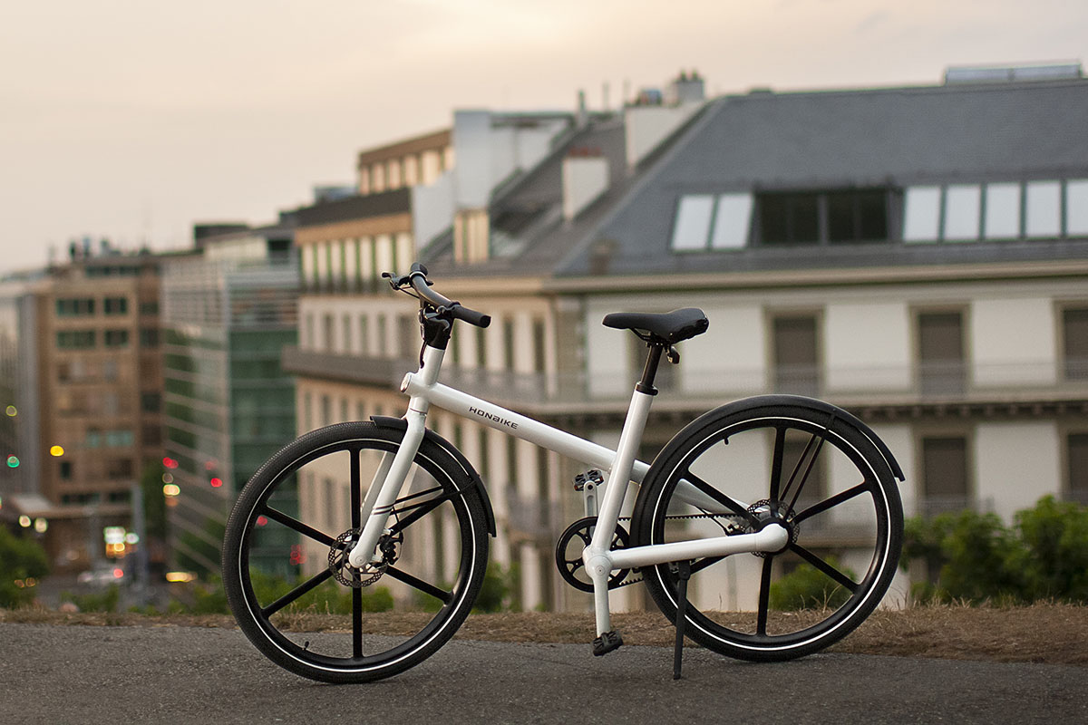 Honbike U4, City-E-Bike mit minimalistischem Rahemdesig steht vor einer Stadtkulisse