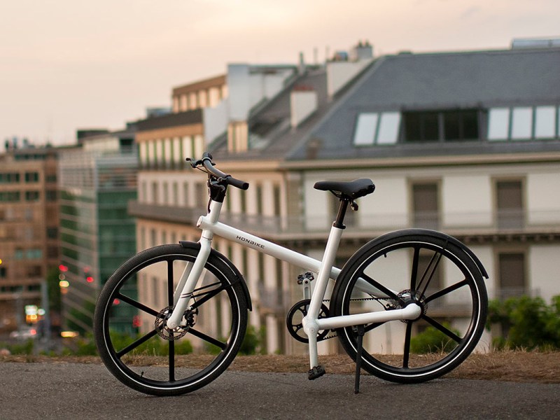 Honbike U4, City-E-Bike mit minimalistischem Rahemdesig steht vor einer Stadtkulisse