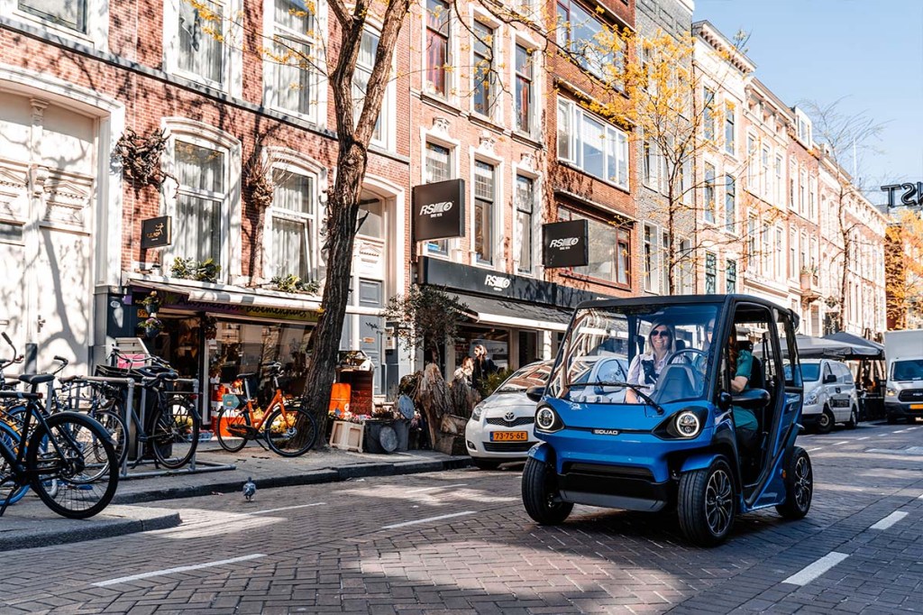 Solar City Car von Squad Mobility in der Stadt fahrend