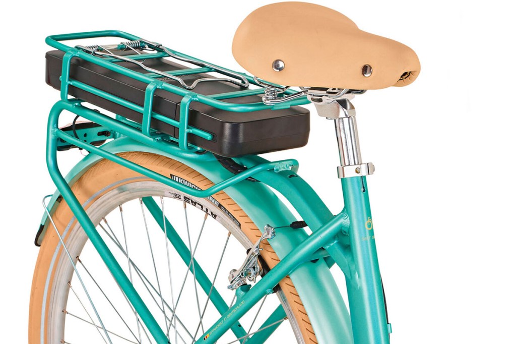 Ein E-Bike-Akku ist auf einem Gepäckträger eines mint-grünen E-Bikes befestigt.