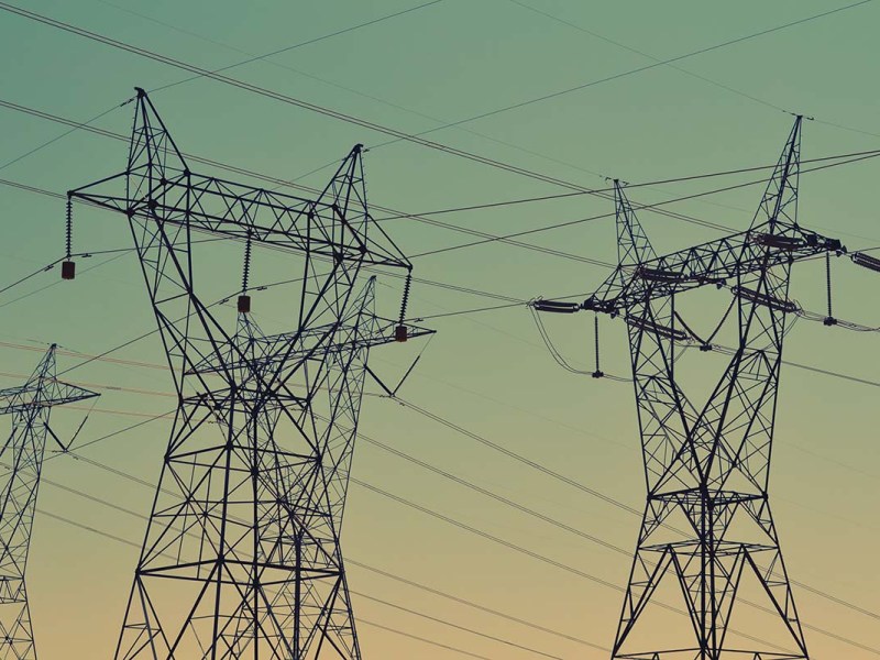 Elektrische Leitungen vor einem Abendhimmel.