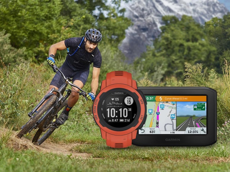 Garmin Smartwatch und Fahrradcomputer vor einem Radfahrer in der Natur.