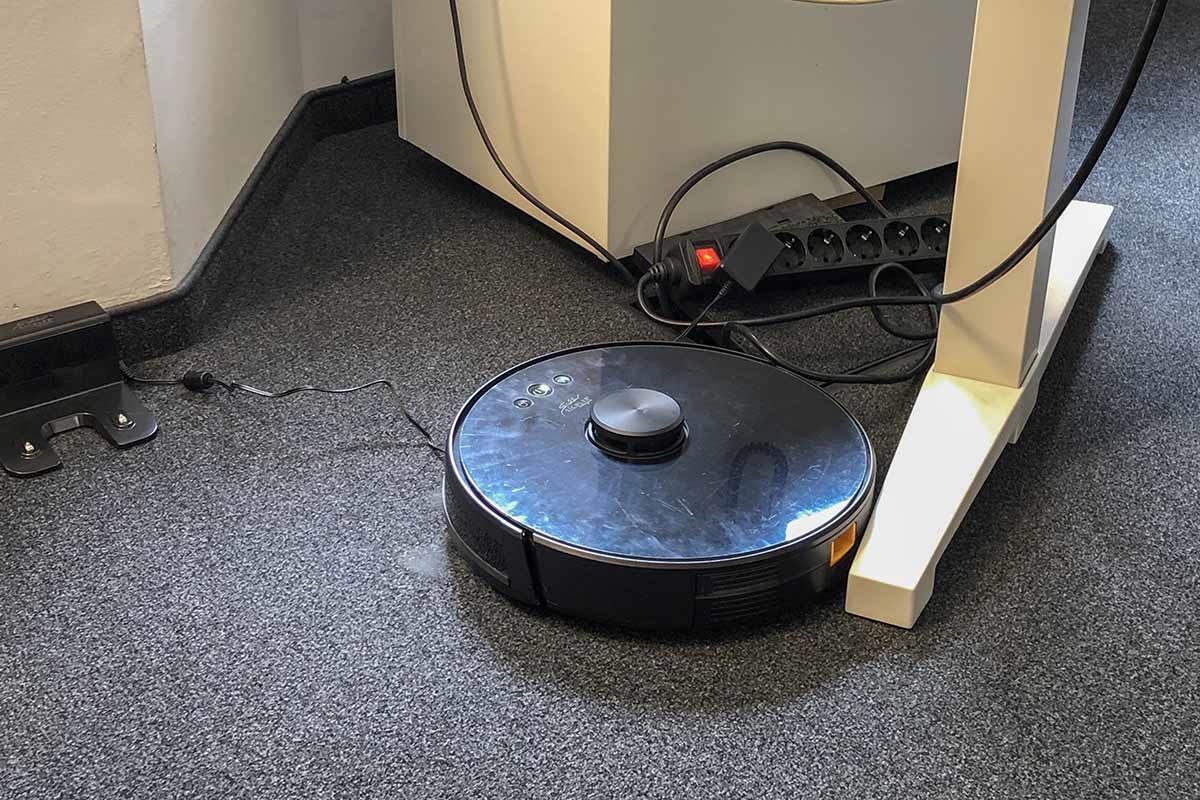 Ein Tischbein verhindert einem Saug-Wisch-Roboter die Weiterfahrt.