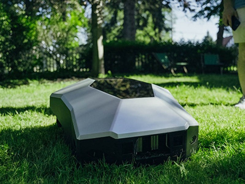 Der neue Lawna Rasenmäh-Roboter im futuristischen Design ist in einer Gartenumgebung gezeigt.