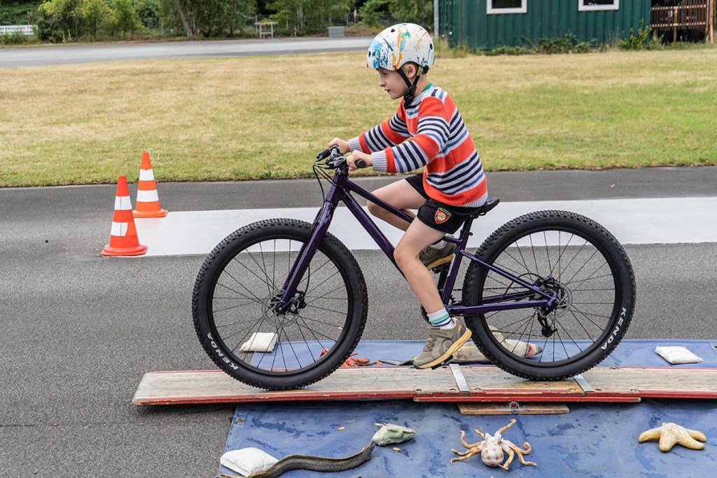 Kind fährt durch eine Strecke mit Hindernissen auf einem Fahrrad