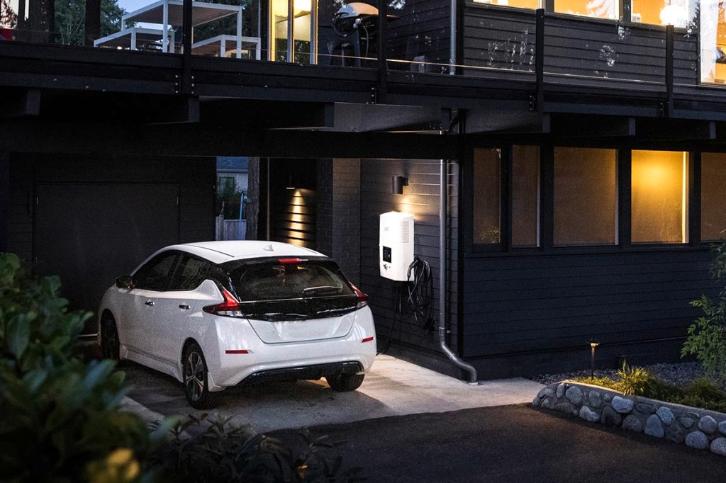 Ein Elektro-Auto wird an der Ladestation in der Garage aufgeladen.
