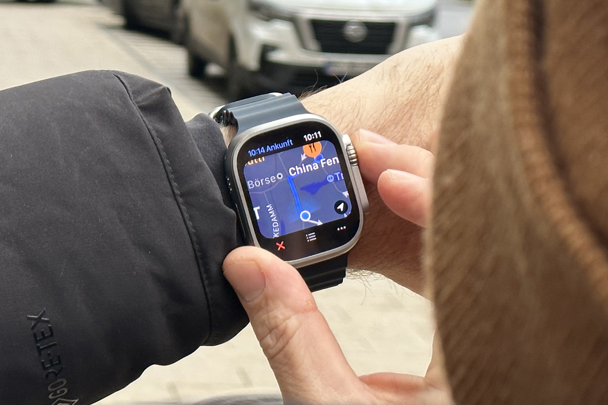 Mann hält Arm mit Smartwatch draußen vor Gesicht