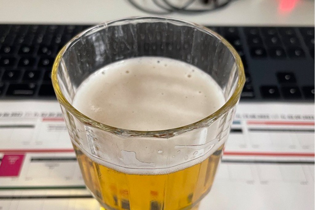 Ein Bierglas steht auf einem Schreibtisch.