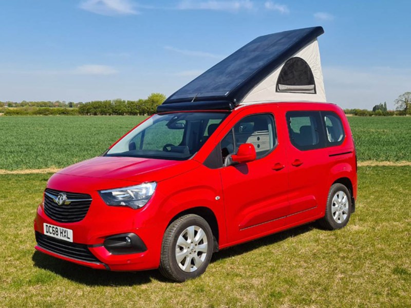 Der Wheelhome Vikenze III-e in rot mit ausgefahrenem Dach in der Natur.